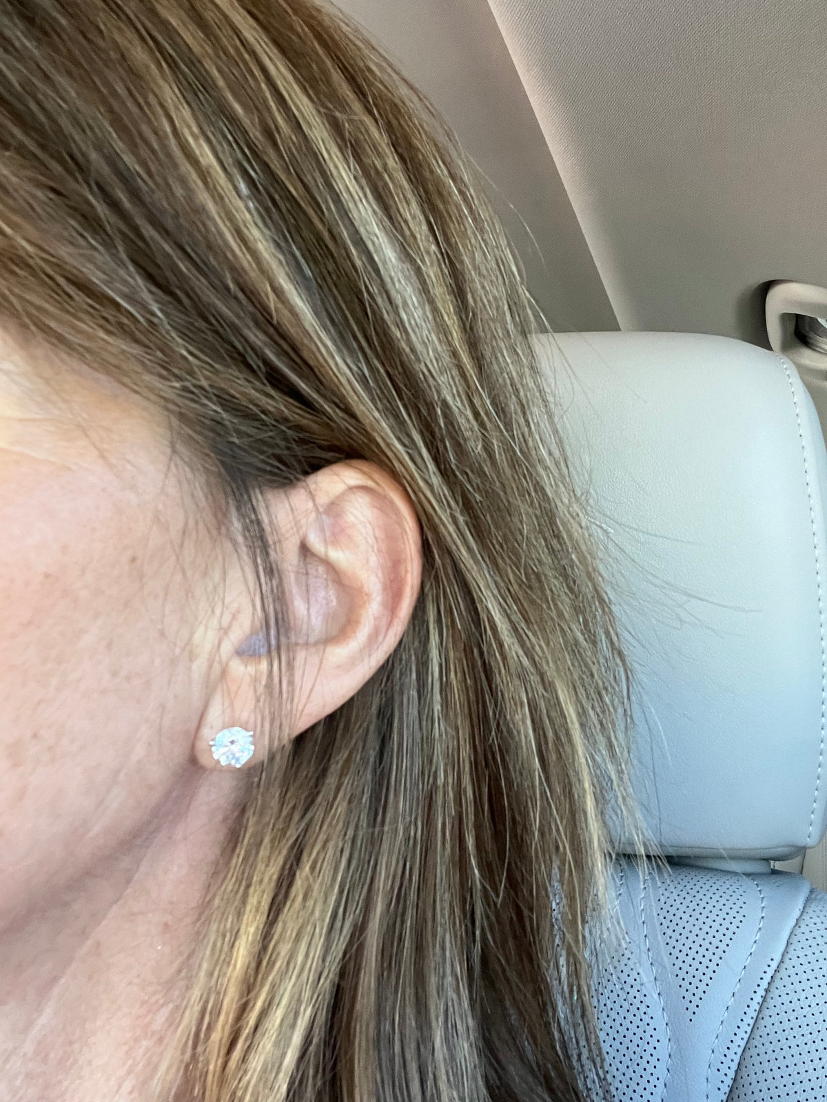 woman wearing a 1.5 carat diamond stud earring
