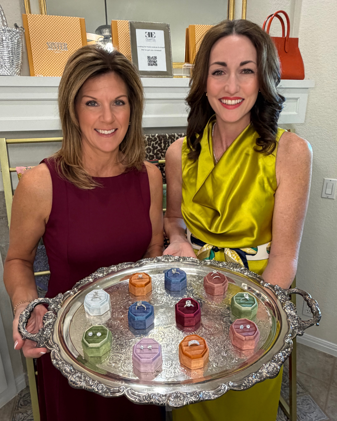 Two Luxury Exchange advisors presenting a tray of diamond engagement rings in velvet boxes.